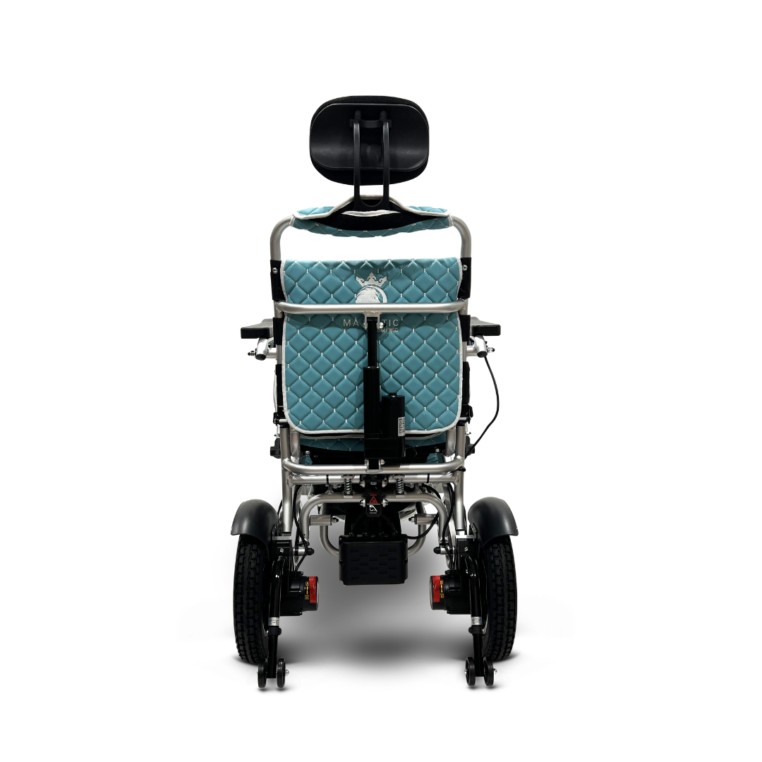 The ComfyGo MAJESTIC IQ-9000 Electric Wheelchair showcases a light blue quilted seat with an automatic reclining feature, a black headrest, large back wheels, smaller front wheels, and sleek metal framing with adjustable components.