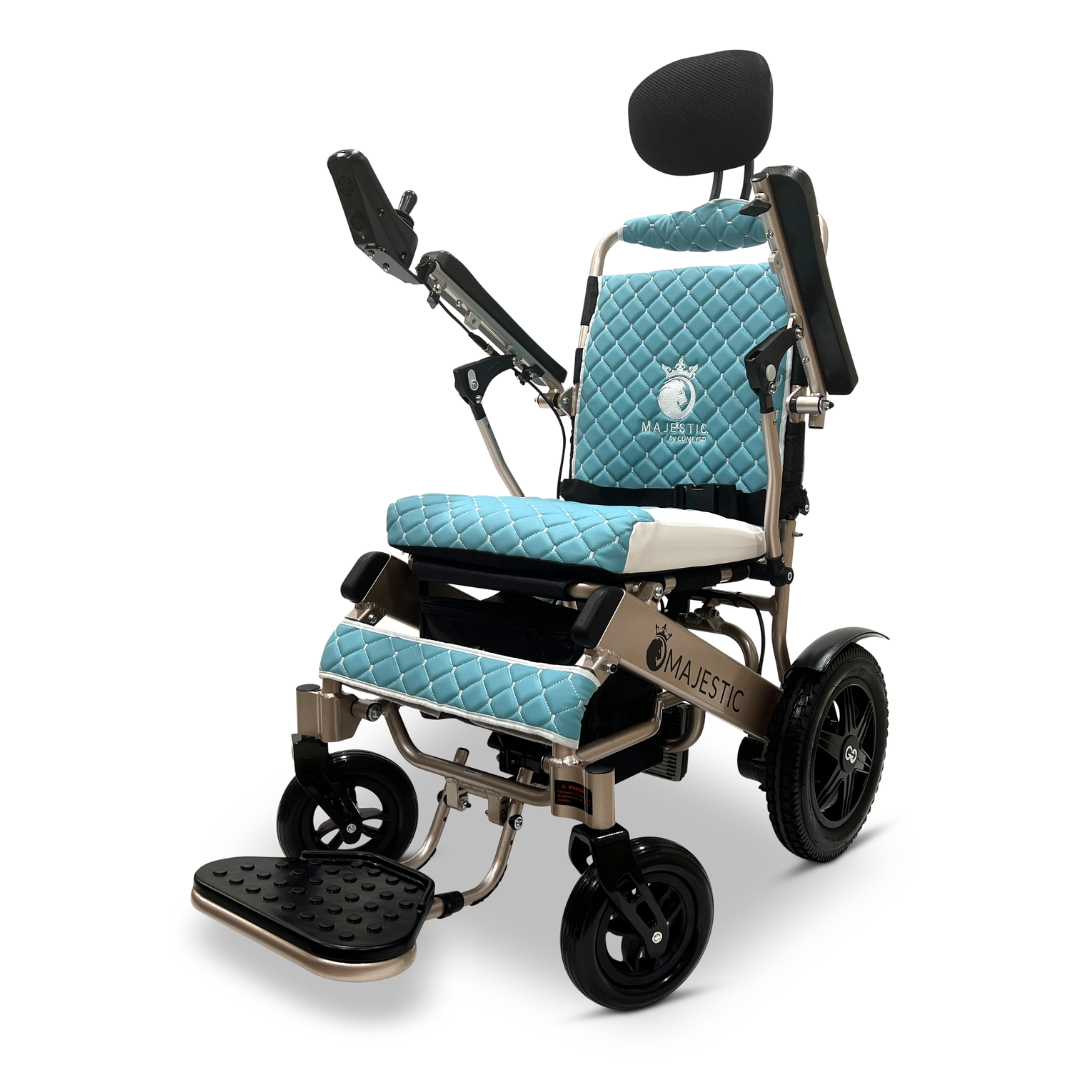 The ComfyGo MAJESTIC IQ-9000 auto recline electric wheelchair showcases a sleek design with blue quilted upholstery, featuring the brand name Majestic on the backrest. It includes a headrest, armrests, an adjustable footrest, and a digital joystick controller for effortless navigation.