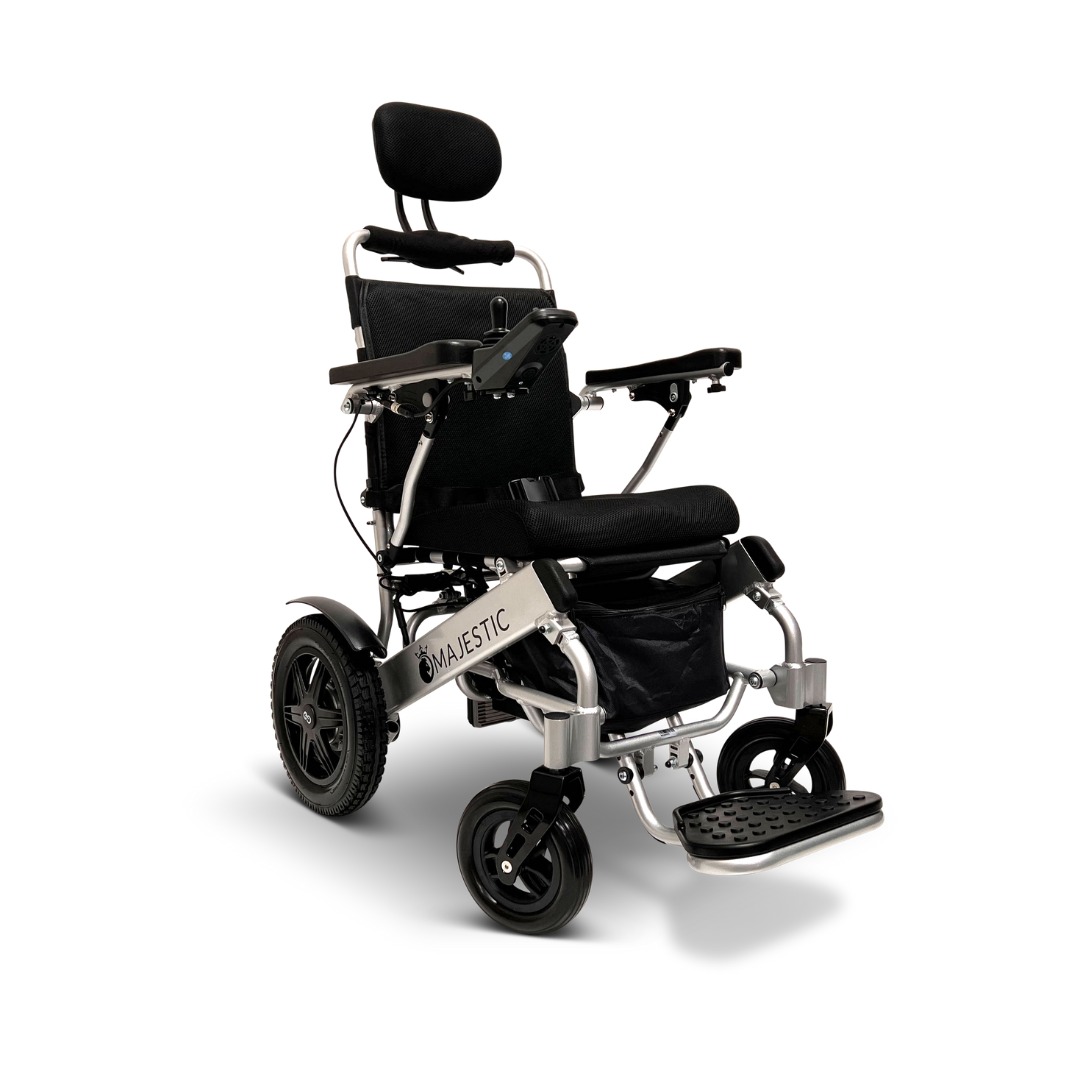The ComfyGo MAJESTIC IQ-9000 is an auto recline remote-controlled electric wheelchair with a black seat, backrest, armrests, and footrest. Its silver frame displays Majestic on the side, with a digital joystick and two large rear wheels plus two small front wheels for smooth navigation.