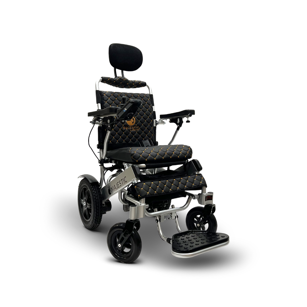 The ComfyGo MAJESTIC IQ-9000 Auto Recline Remote Controlled Electric Wheelchair showcases black and gold diamond-patterned upholstery, armrests, a cushioned headrest, a footplate, and four wheels. It includes an automatic reclining system and digital joystick controller with the Majestic brand on the seat and side.