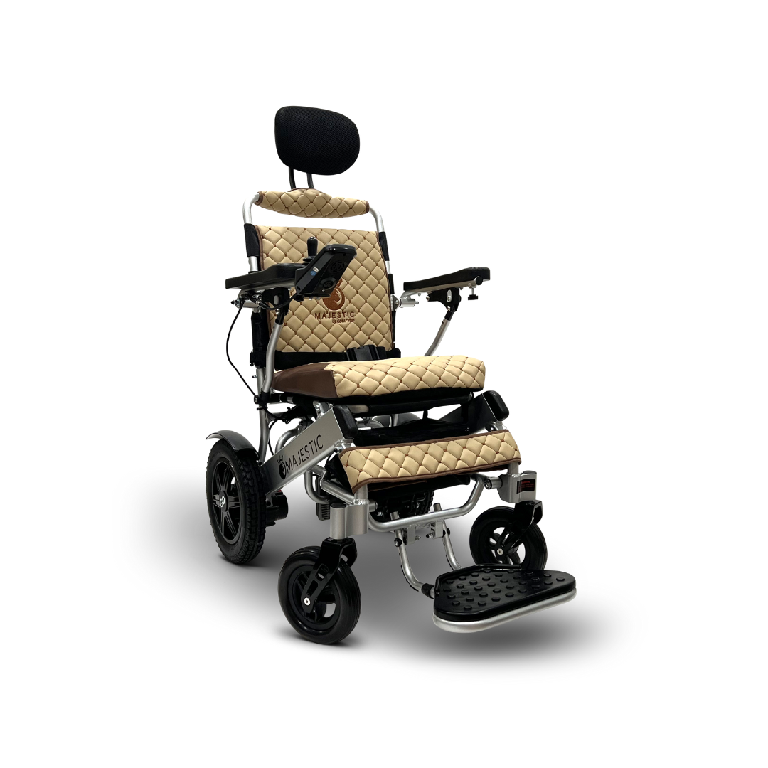 The ComfyGo MAJESTIC IQ-9000 wheelchair features a quilted beige seat and headrest, armrests, foot support, a digital joystick controller, and four wheels for stability. Designed for ultimate comfort, it offers remote-controlled automatic reclining for personalized mobility assistance.