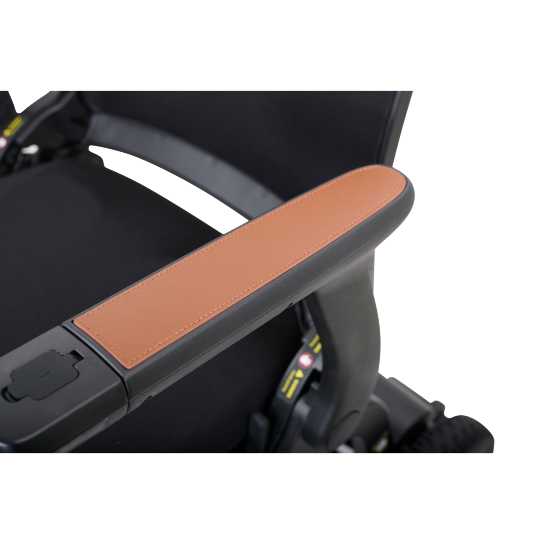 Close-up of the Golden Tech Ally Folding Power Wheelchairs armrest, showcasing a sleek black frame with brown leather-like padding. This foldable design emphasizes comfort and style, making it an ideal travel companion.