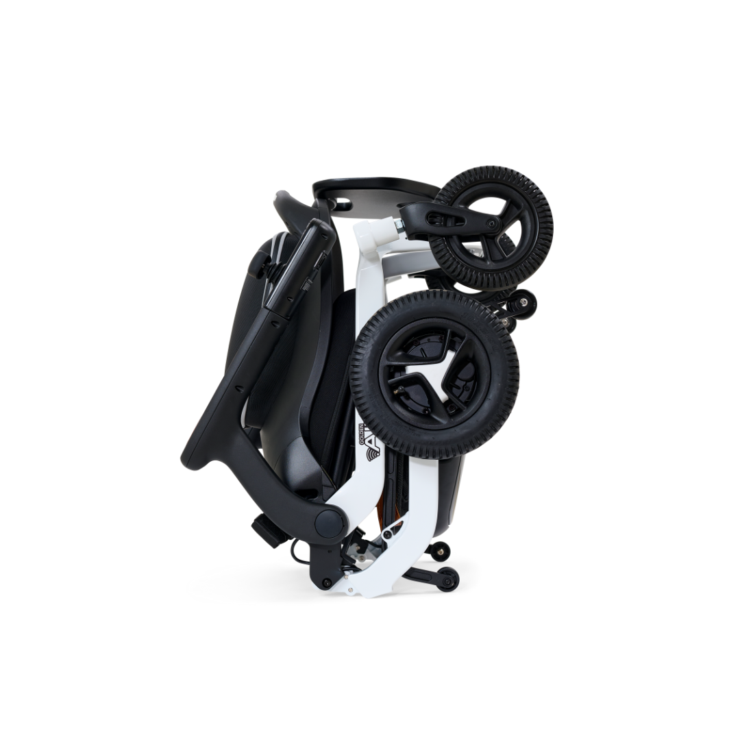 A folded black and white Golden Tech Ally Folding Power Wheelchair with large wheels, designed for compact storage and easy transport—your perfect travel companion. The image shows a side view of the wheelchair in its folded position, ready to accompany you on any journey.