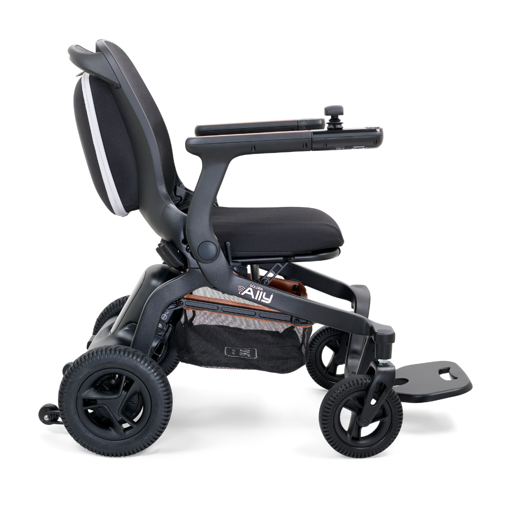 Side view of the Golden Tech Ally Folding Power Wheelchair, a modern black foldable chair with four wheels, an armrest joystick, and under-seat storage. Its compact design is perfect for travel, and the Smart Control Mobile App boosts its indoor/outdoor usability.