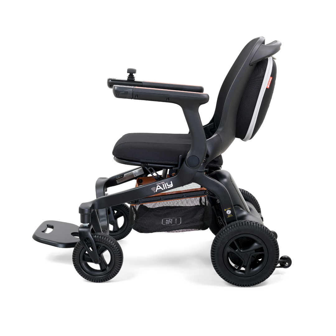 Side view of the Golden Tech Ally Folding Power Wheelchair in black. It features a padded seat, armrests with a small control panel, four sturdy wheels, and mobile app control, making it a sleek and ideal travel companion for easy mobility.
