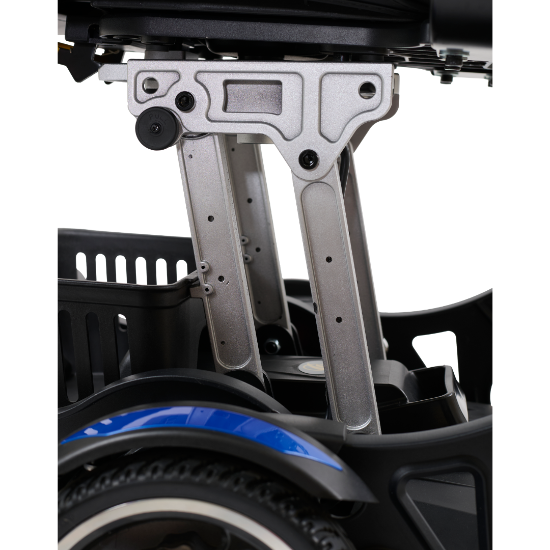 Close-up of the ultra-compact Golden Tech GP130 Buzzaround CarryOn Portable Powerchairs mechanical structure, highlighting metal joints and supports. A small basket is visible, while part of its folding wheel with a decorative blue stripe appears in the foreground.