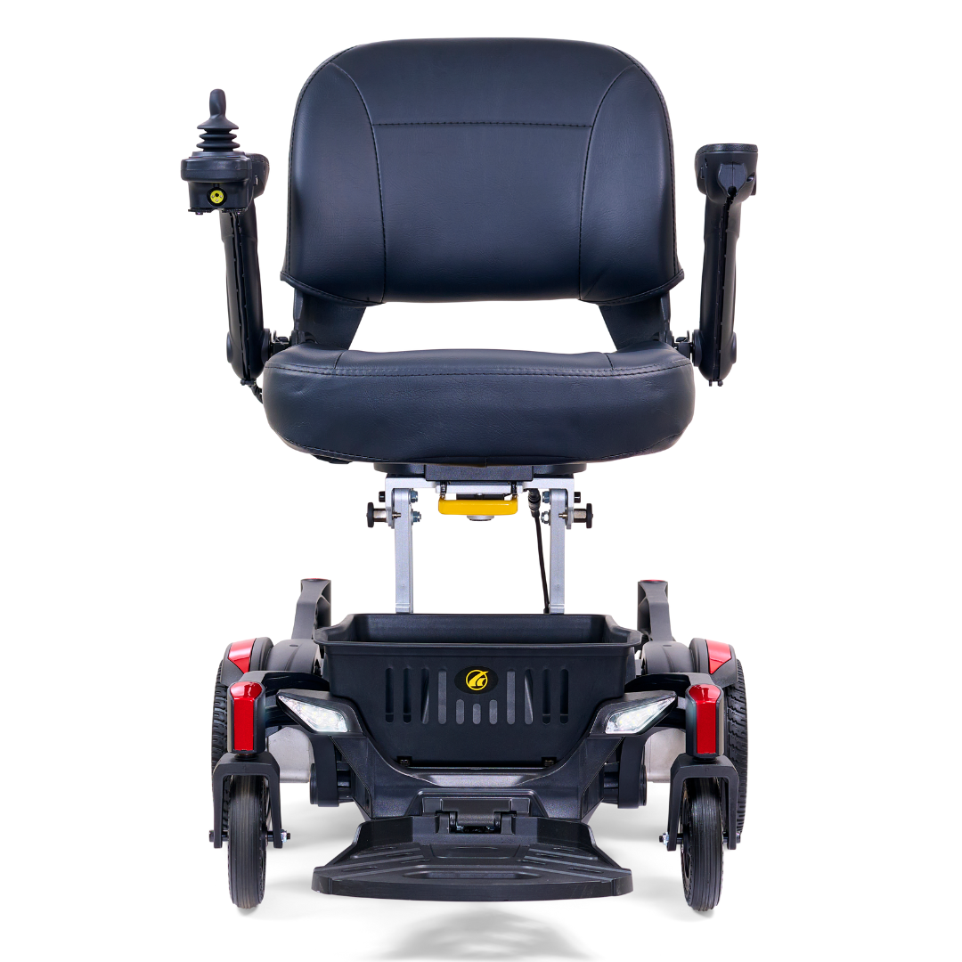 The Golden Tech GP130 Buzzaround CarryOn Portable Powerchair is an ultra-compact black mobility scooter with a cushioned seat, armrests, joystick control on the armrest, and four wheels with a 4-wheel suspension system. It also features red accents on the front.
