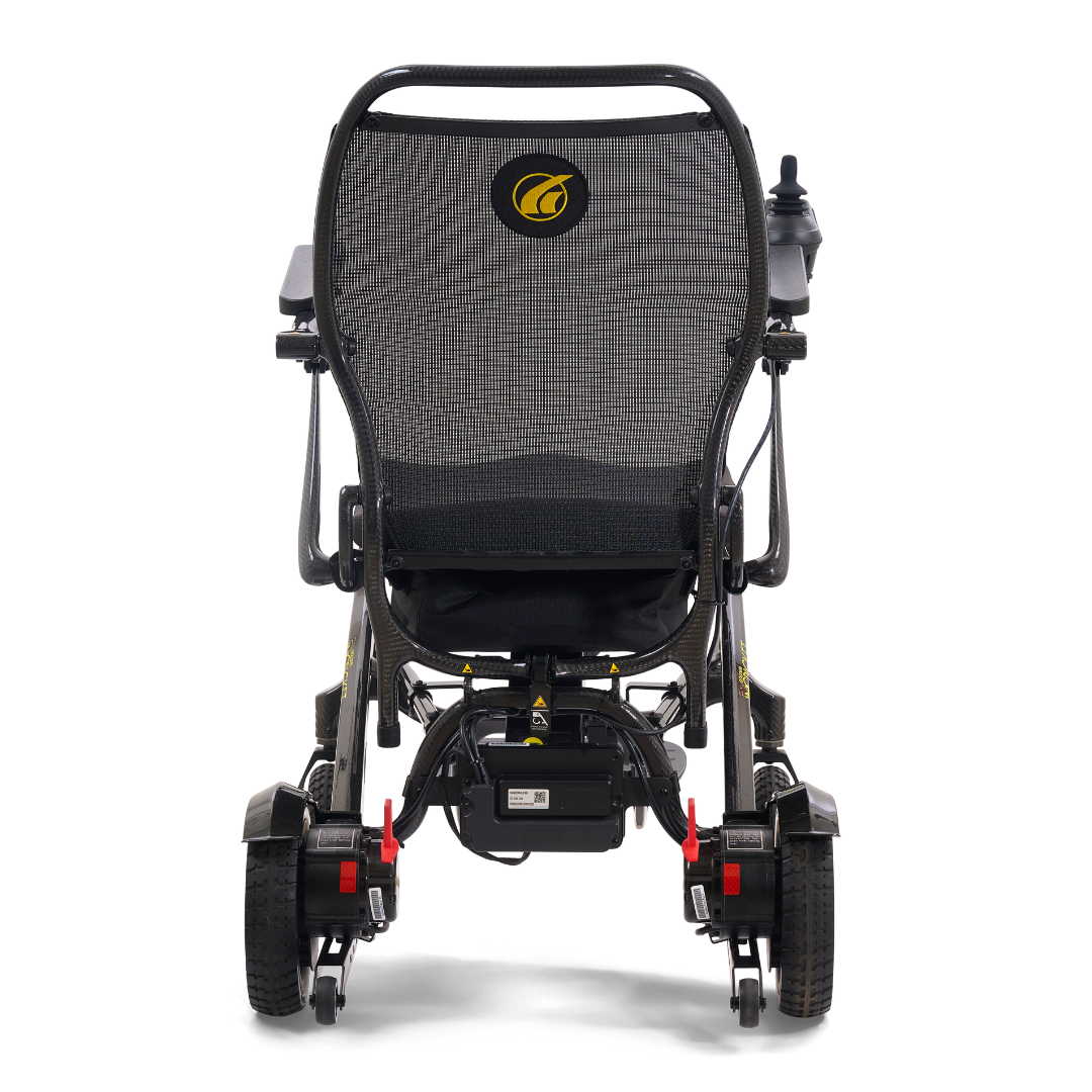 Rear view of the Golden Tech Carbon Fiber Cricket Power Wheelchair (only 33 lbs) with mesh backrest, right arm joystick, large rear wheels, and a yellow circular logo on the lightweight frame.