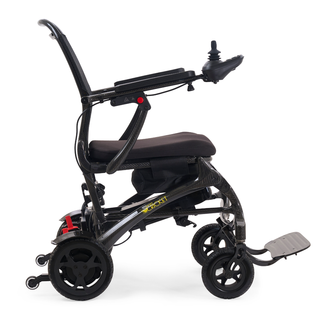 The Golden Tech Carbon Fiber Cricket Power Wheelchair, weighing only 33 lbs, is a lightweight black chair with right-arm joystick control, padded seat, folding frame, and footrest, shown from the side against a white background.