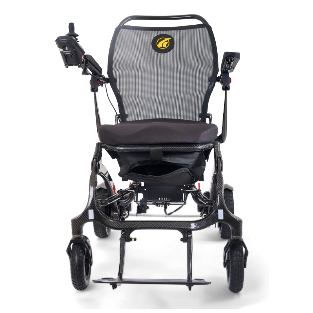 The Golden Tech Carbon Fiber Cricket Power Wheelchair weighs only 33 lbs and features a lightweight, foldable design with a mesh backrest, cushioned seat, armrest joystick controls, and small front and rear wheels, shown from the front on a white background.