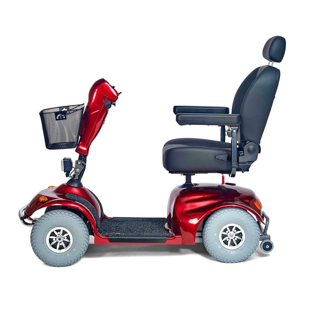 The Golden Tech Avenger HD Bariatric Mobility Scooter is a heavy-duty, four-wheeled red scooter with a black padded seat and adjustable backrest and armrests. Its equipped for rugged terrain and includes a front handlebar basket for convenience on long journeys.