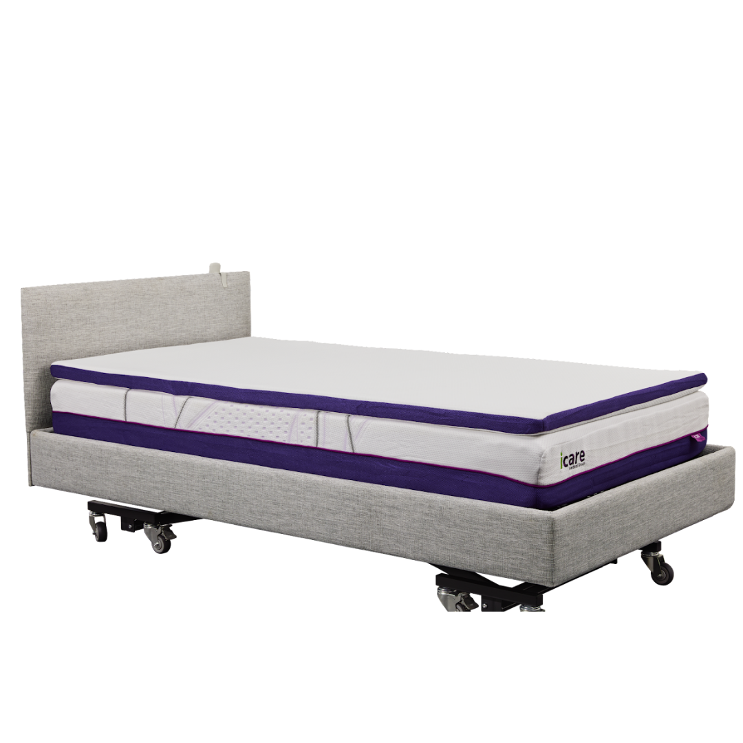 The iCare Medical IC100 Static Partner Non-Adjustable Bed is a grey hospital-grade bed with wheels, thick white-and-purple layered mattress, antibacterial vinyl finish, simple upholstered headboard, and optional iCare bed rails for extra safety.