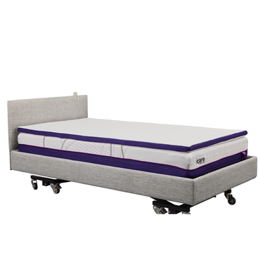 The iCare Medical IC100 Static Partner Non-Adjustable Bed is a grey hospital-grade bed with wheels, thick white-and-purple layered mattress, antibacterial vinyl finish, simple upholstered headboard, and optional iCare bed rails for extra safety.