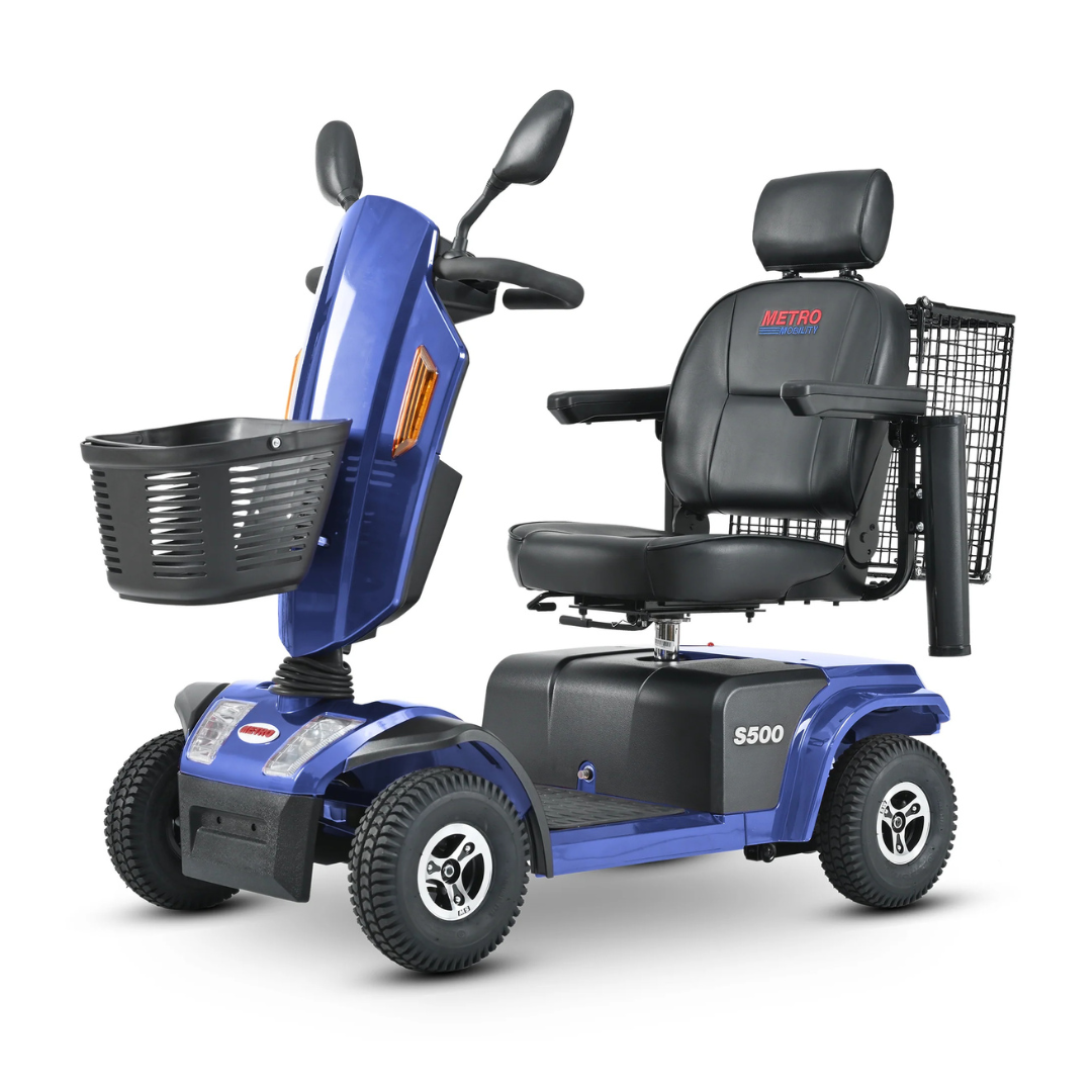 The Metro Mobility S500 Heavy Duty 4-Wheel Power Scooter, in blue, includes a black padded seat with headrest and armrests, a front basket, rearview mirrors, and displays the S500 model label on the side. It also features a silver brand logo on the footrest for added flair.