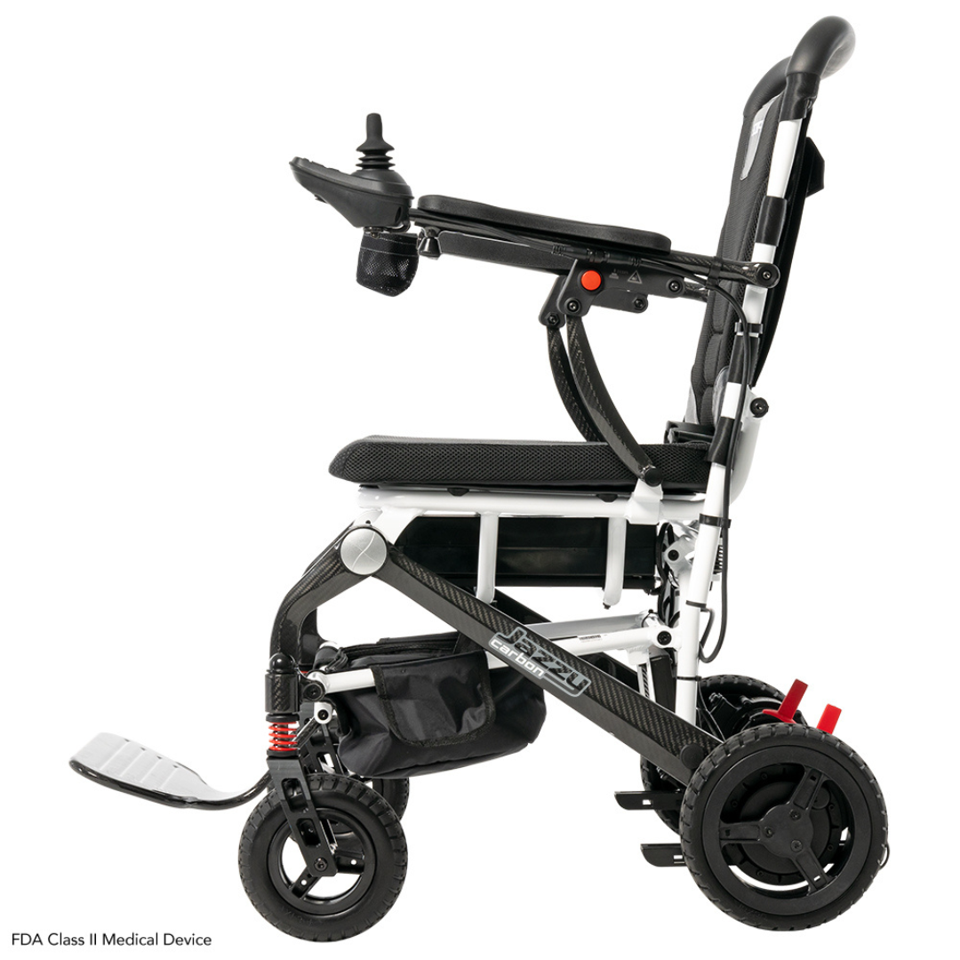 The Pride Mobility Jazzy® Carbon Ultralite Powerchair is a compact, foldable black and white electric wheelchair featuring an airline-compliant lithium battery. It has a removable joystick with USB charger on the right armrest, footrest, and sturdy wheels for optimal mobility and convenience.