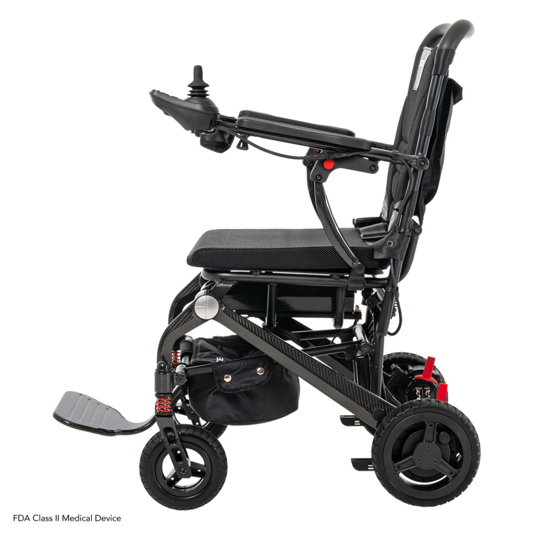 The Pride Mobility Jazzy® Carbon Ultralite Powerchair features joystick control, side view, ultra-light construction for easy travel, cushioned seating, foldable footrest, and sturdy wheels for smooth mobility. Its compact frame ensures effortless maneuverability.