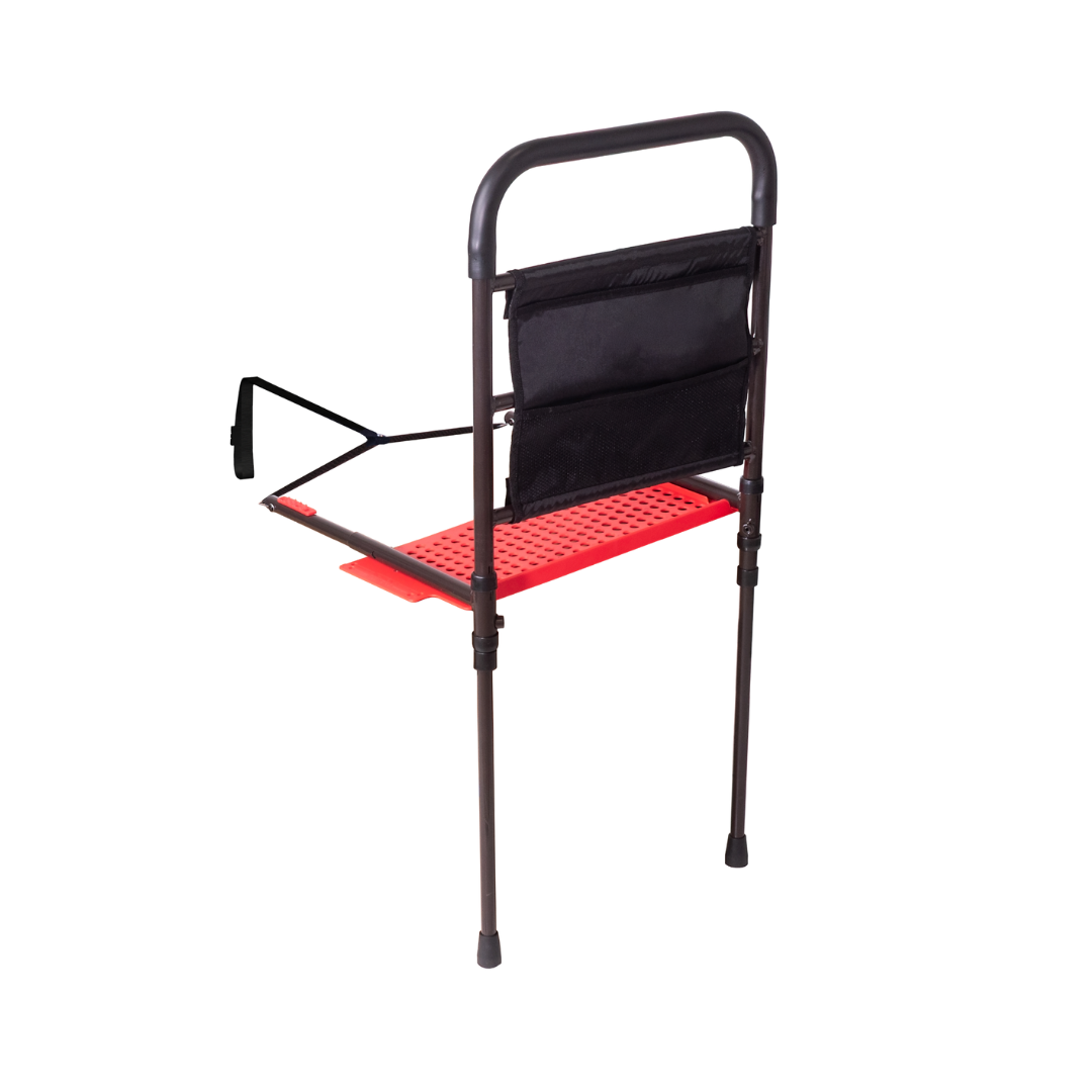 The Stander Stable Rail Bedside Standing Aid with extendable legs features a black metal frame, adjustable handle, red perforated tray, and black pouch for support and storage, shown on a white background.