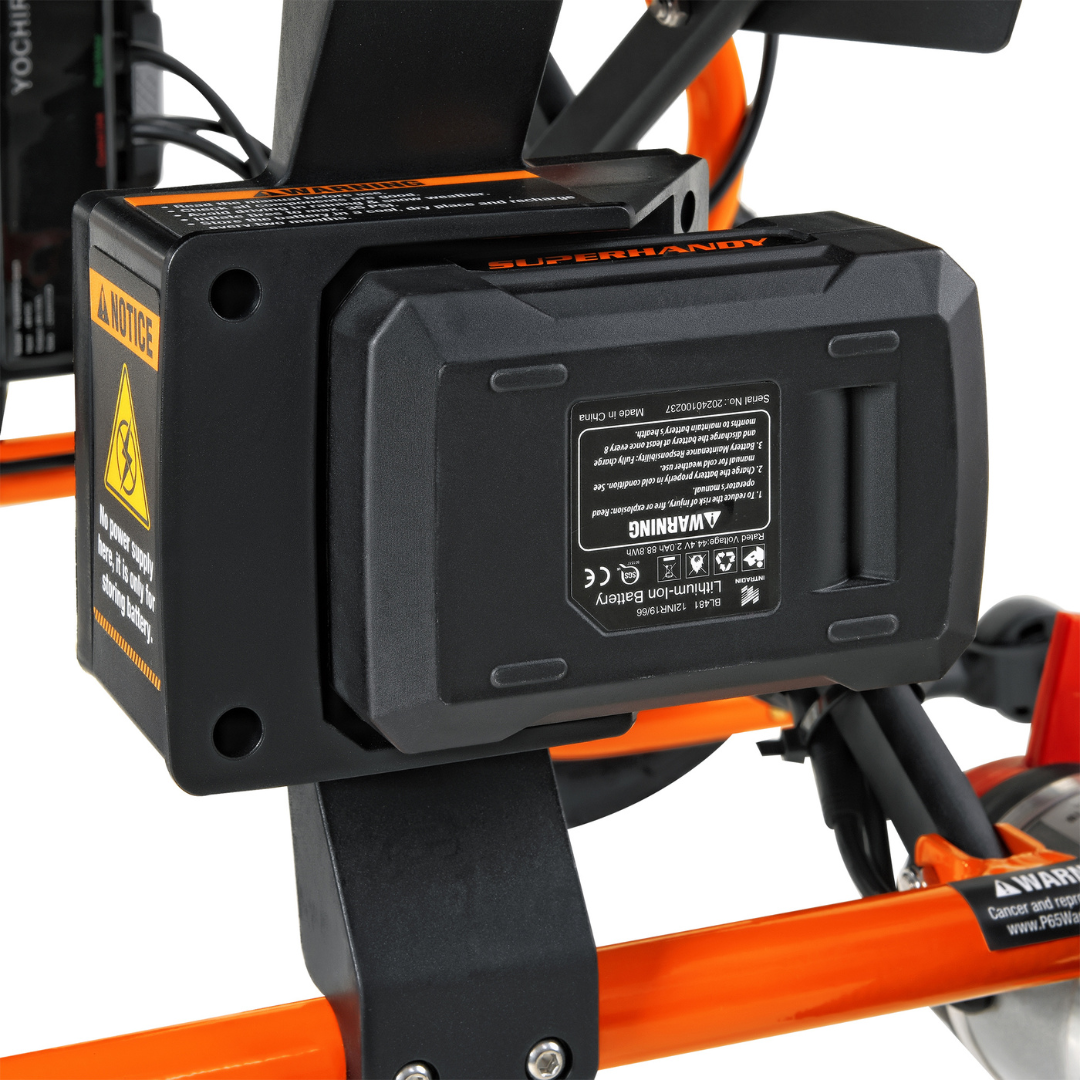 Close-up of a SuperHandy GoRide 2 Portable Electric Wheelchair battery, featuring warning labels and ergonomic controls on an orange frame against a white background, highlighting its intricate details.