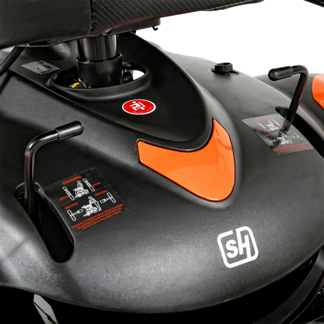 A close-up of a black and orange control panel from the SuperHandy GoRide CRX Powerchair, showcasing levers, a red circular button, and an SH logo.