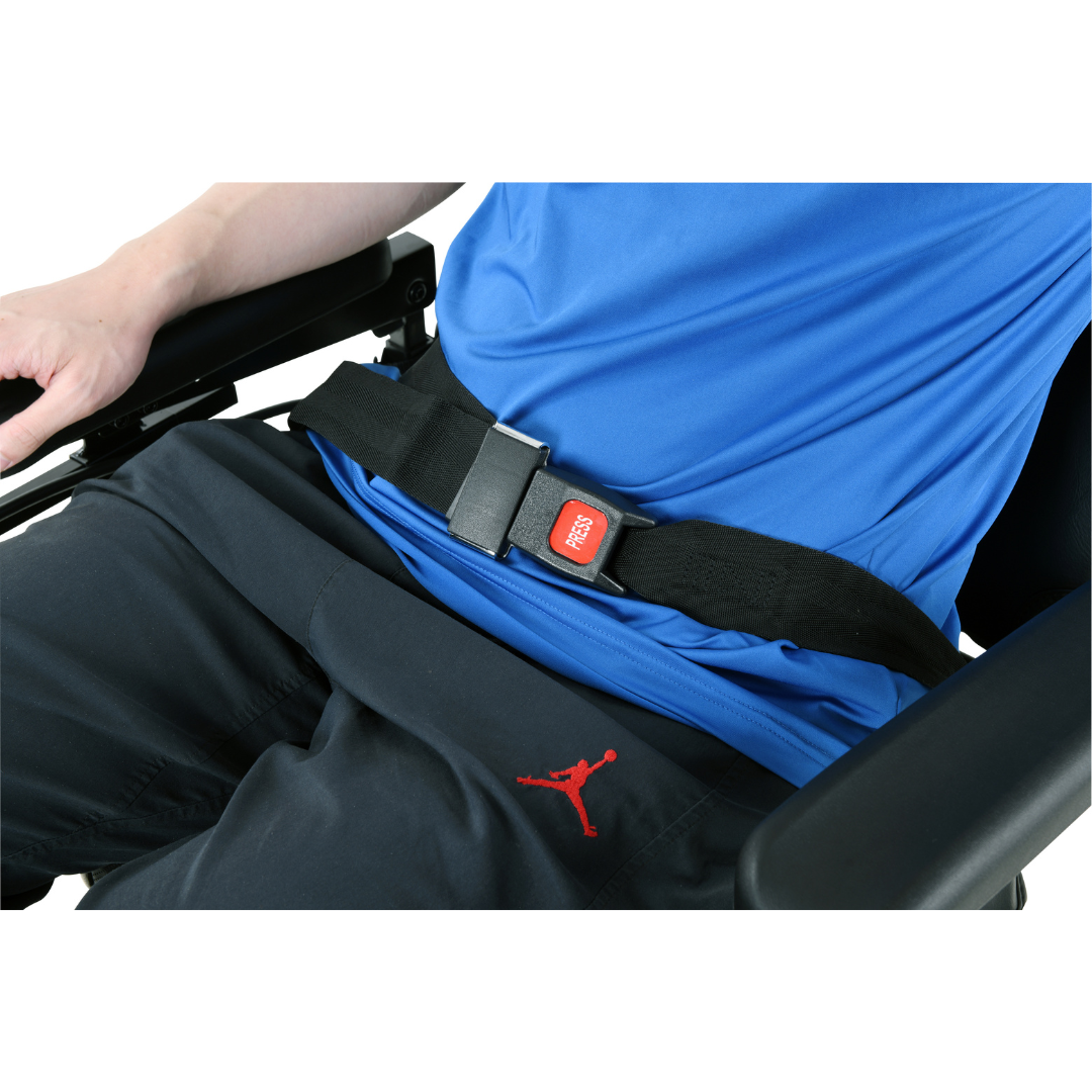 A person in a SuperHandy GoRide CRX Powerchair is wearing a seatbelt for safety, clad in a blue shirt and black pants with a logo. The midsection highlights the seatbelts clasp, ensuring comfort during all-day use of this mid-wheel drive chair with a 12.8-mile range.