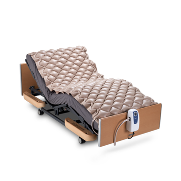 The Wellell Domus 1 Alternating Pressure Mattress is shown on an adjustable hospital bed with a beige overlay for pressure ulcer prevention, wooden headboard and footboard, black frame, and attached controller against a white background.
