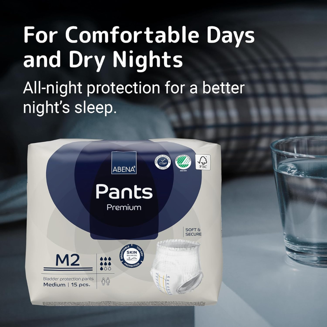A package of Abena Pants Premium Protective Adult Underwear sits on a table next to a glass of water, with text above: For Comfortable Days and Dry Nights. Enjoy all-night absorbent protection for better sleep.