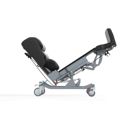 Side view of the Accora Configura® Advance Postural Tilt Chair in black and gray, featuring padded cushions and wheels, shown partially reclined for adaptable comfort.