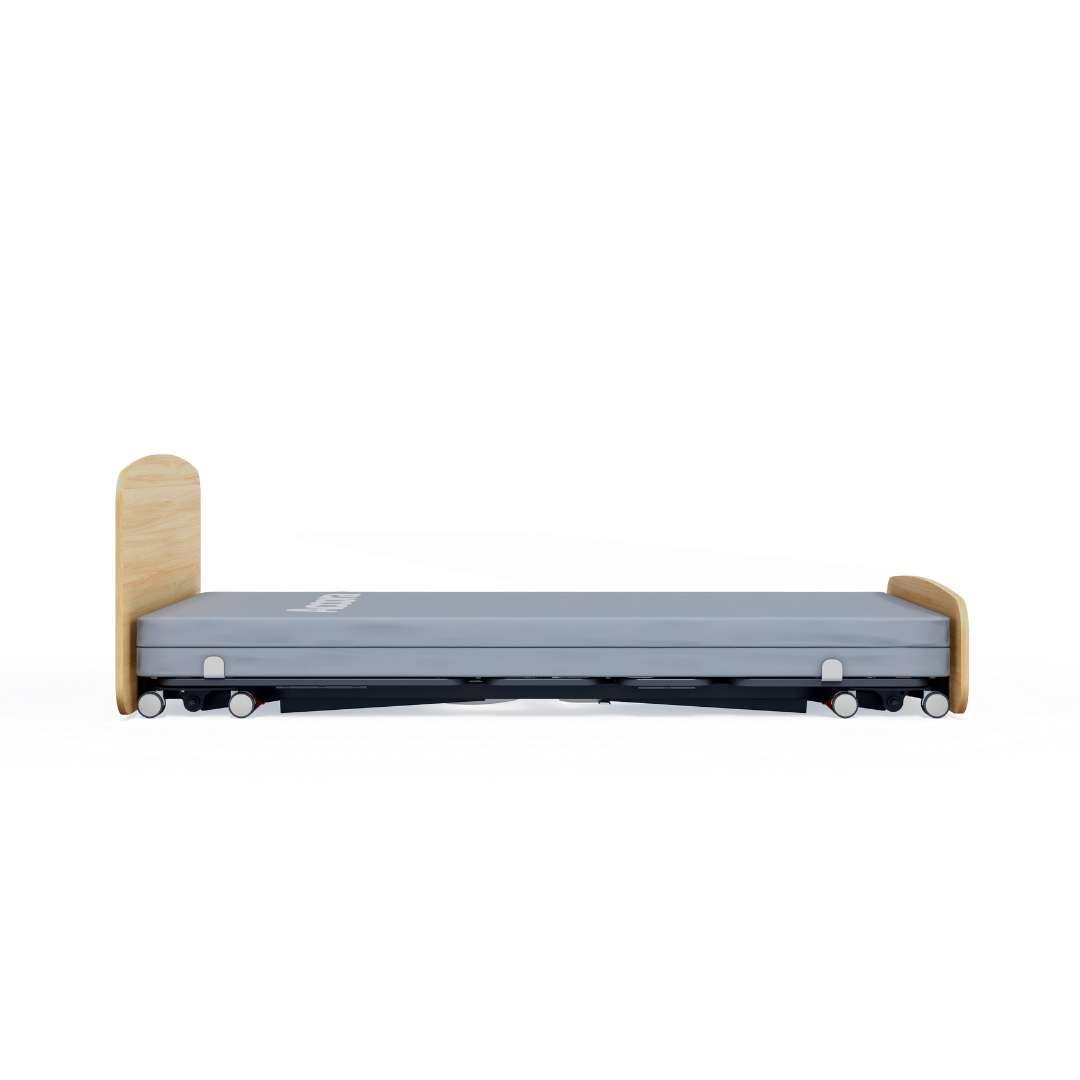 The Accora Contesa® FloorBed® Hi/Low Full Electric Bed is a low-profile hospital bed with light wooden boards, grey mattress, and wheels—a floor-level fall-prevention solution shown side view against a white background.