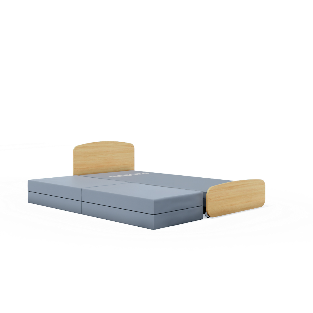 The Accora Contesa® FloorBed® Hi/Low Full Electric Bed features a low, gray foldable mattress and two light wood headboards at opposite ends—an ideal discreet fall-prevention solution against a plain white background.