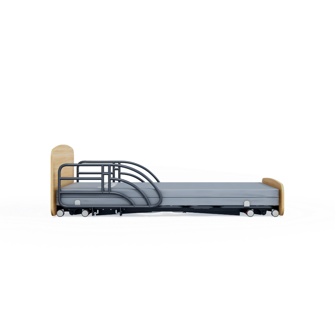 The Accora Contesa® FloorBed® Hi/Low Full Electric Bed is a modern hospital bed with a light wood headboard/footboard, metal safety rails, and wheels—a smart fall-prevention solution, shown from the side against a white background.