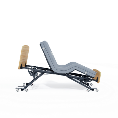 The Accora Contesa® FloorBed® Hi/Low Full Electric Bed features a grey mattress, wooden headboard and footboard, shown reclined on wheels against a white background—engineered for fall prevention, safety, and comfort.