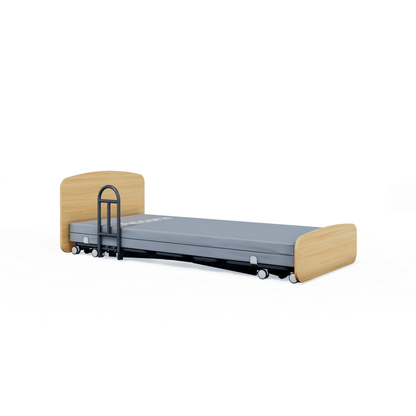 The Accora Contesa® FloorBed® Hi/Low Full Electric Bed features a low-profile design with a light wooden headboard and footboard, gray mattress, safety rail for fall prevention, small wheels for mobility, and is set against a plain white background.