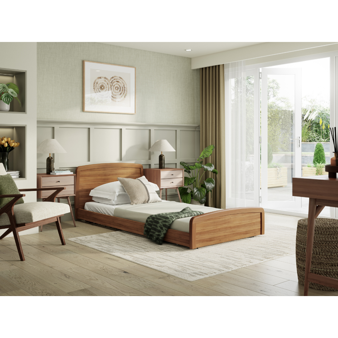 A bright bedroom showcases the Accora Contesa® FloorBed® Hi/Low Full Electric Bed with white bedding, nightstands, lamps, a green throw, plants, a chair and desk—all illuminated by large glass doors to the patio for safe, elegant living.