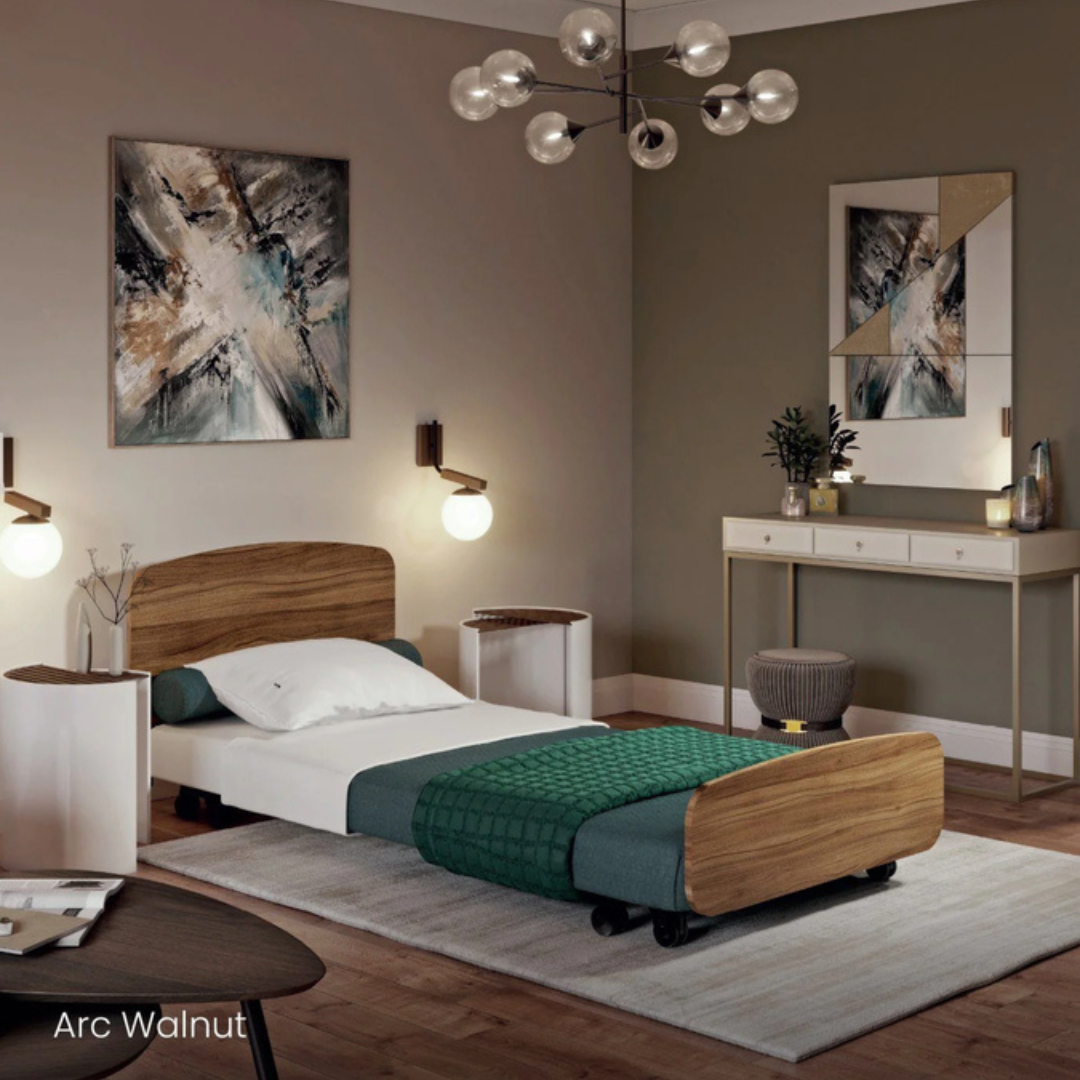 A modern bedroom with a single Accora Contesa® FloorBed® Hi/Low Full Electric Bed featuring walnut accents and a green blanket, abstract wall art, stylish lighting, a white console table, and plants on a light rug and wooden floor.