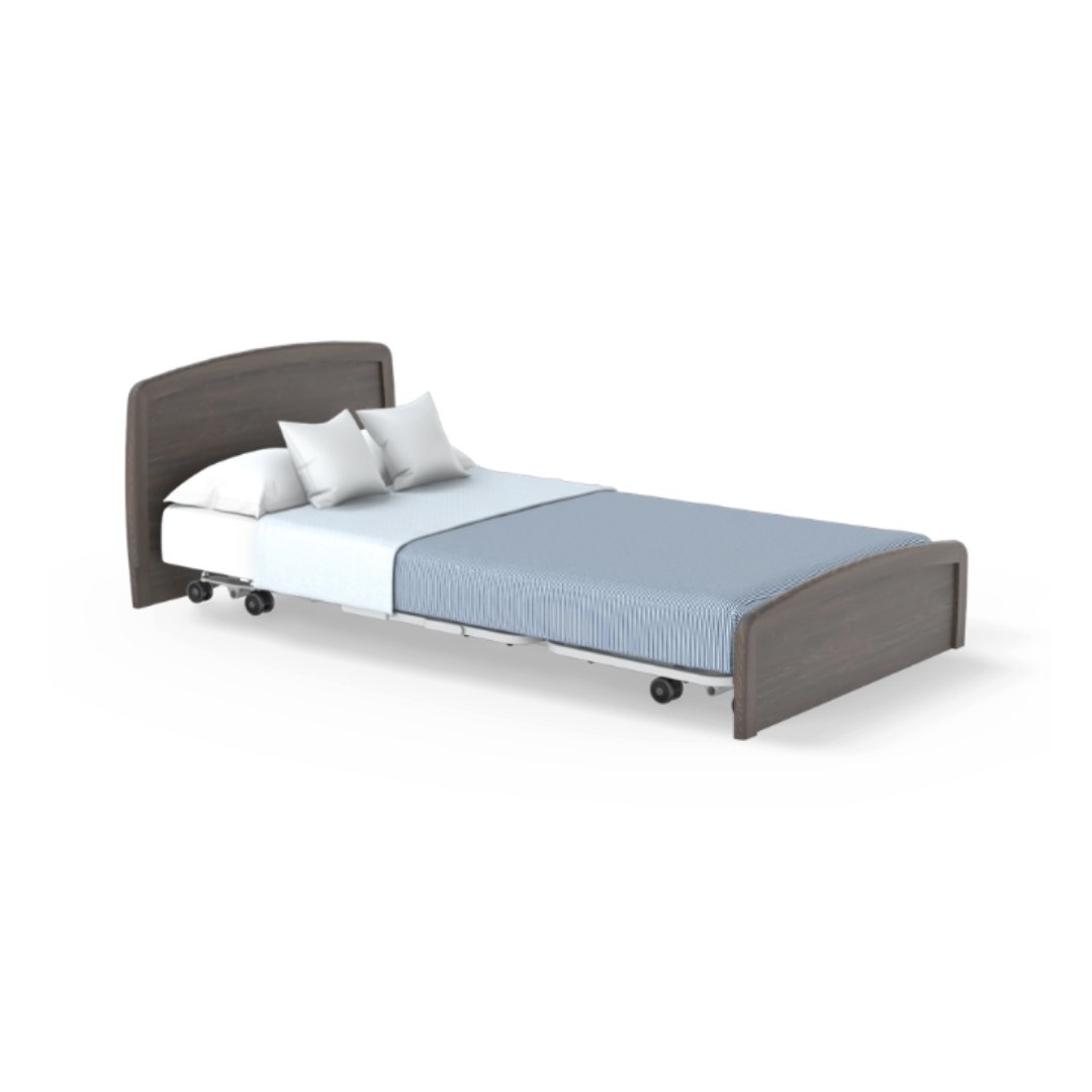 The Accora Empresa® Full Electric Bariatric FloorBed® is shown with a dark wood headboard and footboard, white mattress, light blue blanket, crisp white sheet, two white pillows, and wheels for mobility on a clean white background.