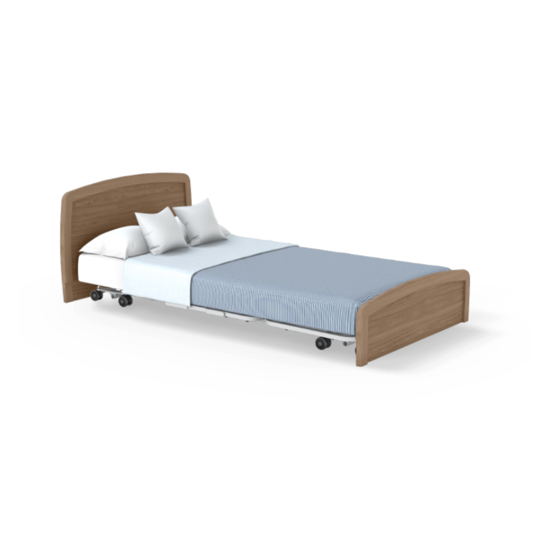 The Accora Empresa® Full Electric Bariatric FloorBed® features a wooden headboard and footboard, white bedding, two white pillows, and a light blue-striped blanket. The bed is on wheels and set against a plain white background.