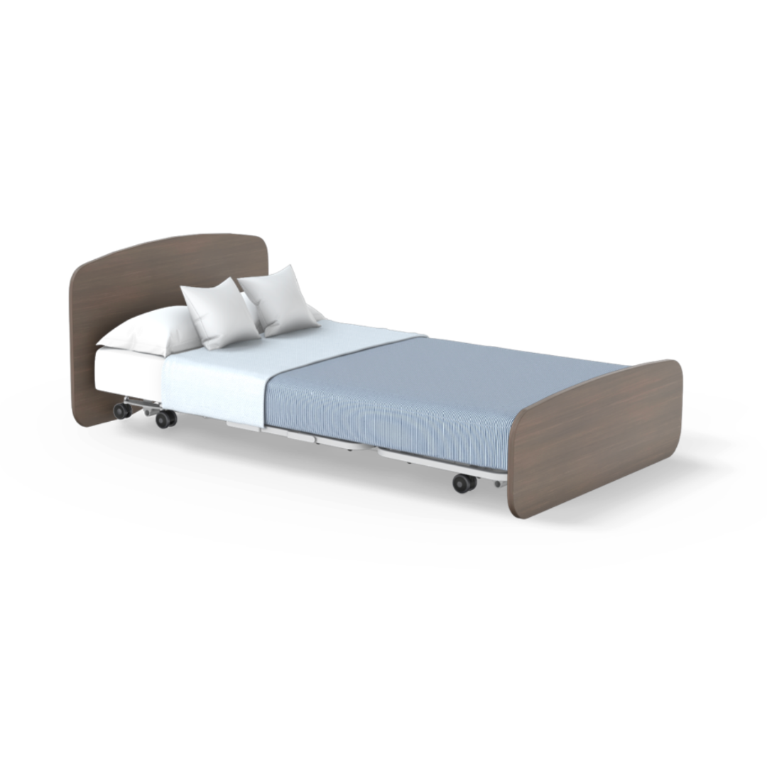 The Accora Empresa® Full Electric Bariatric FloorBed® is shown with a wooden headboard and footboard, white bedding, blue blanket, two white pillows, and wheels on the base against a plain white background.