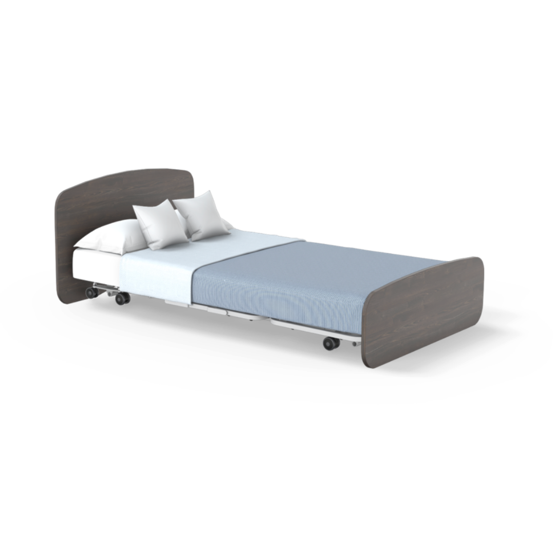 The Accora Empresa® Full Electric Bariatric FloorBed® features a dark wooden headboard and footboard, white mattress, two white pillows, light blue bedding, and wheels—perfect for versatile bedroom styling on a white background.