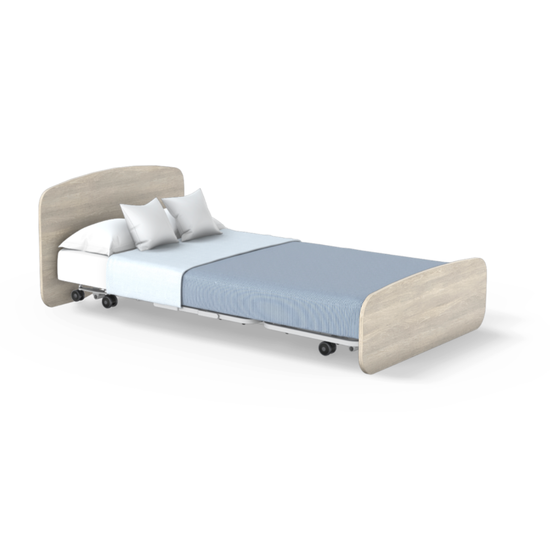 The Accora Empresa® Full Electric Bariatric FloorBed® features a light wood headboard and footboard, white mattress, two white pillows, and a blue blanket. The wheeled bed is displayed against a white background.