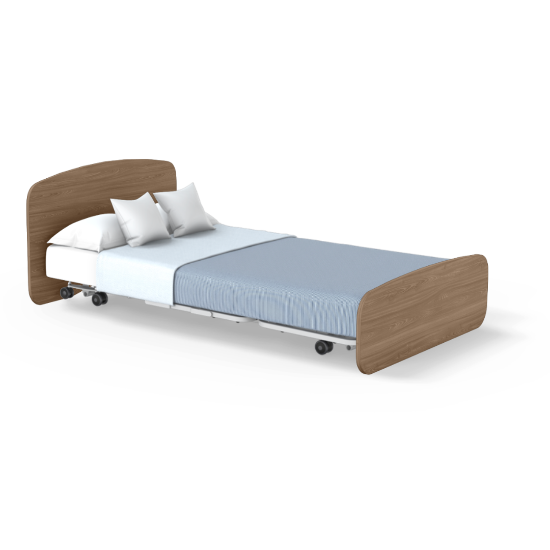 The Accora Empresa® Full Electric Bariatric FloorBed® features a light wood headboard and footboard, a light blue sheet, white blanket, two white pillows, and lockable wheels. Shown against a white background.