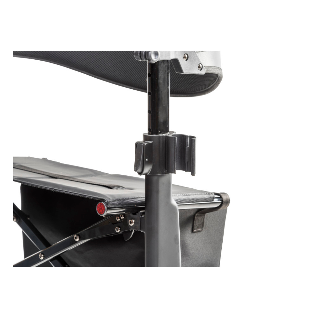 Close-up of the Drive AeroCarbon Ultra-Lite Rollator in black carbon fiber, showing the frame, joint, and side storage pocket, with part of the seat and backrest visible.