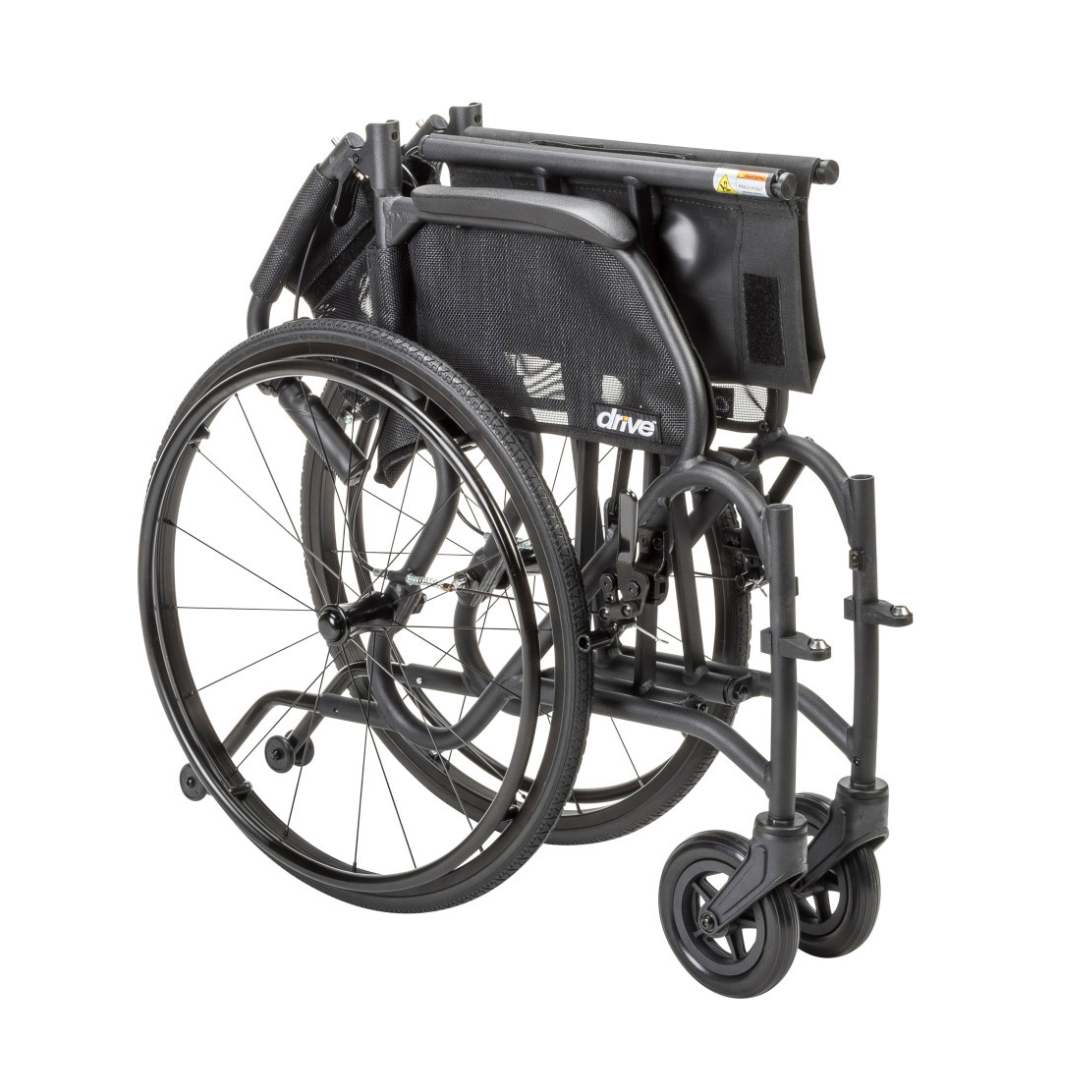 The Drive AeroFly™ Ultra-Lite Wheelchair with Companion Brakes is a lightweight, black travel chair that folds compactly for storage or transport, bringing the seat, footrests, and wheels closely together.