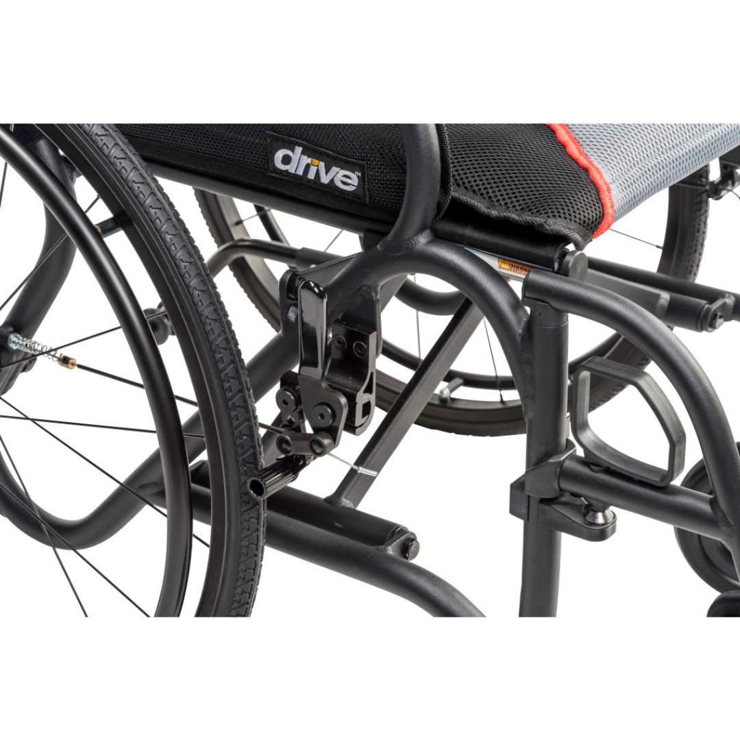 Close-up of the Drive AeroFly™ Ultra-Lite Wheelchair with Companion Brakes in black, highlighting its lightweight frame, wheel, locking mechanism, and the Drive logo on the seat upholstery.