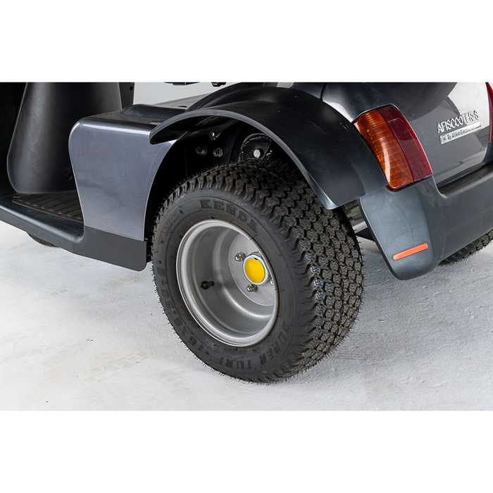 Close-up of a black scooters rear wheel and tire on white background, featuring a textured tread pattern. Afikim Electric Vehicle Accessories enhance the body design, including a reflective red strip near the wheel.