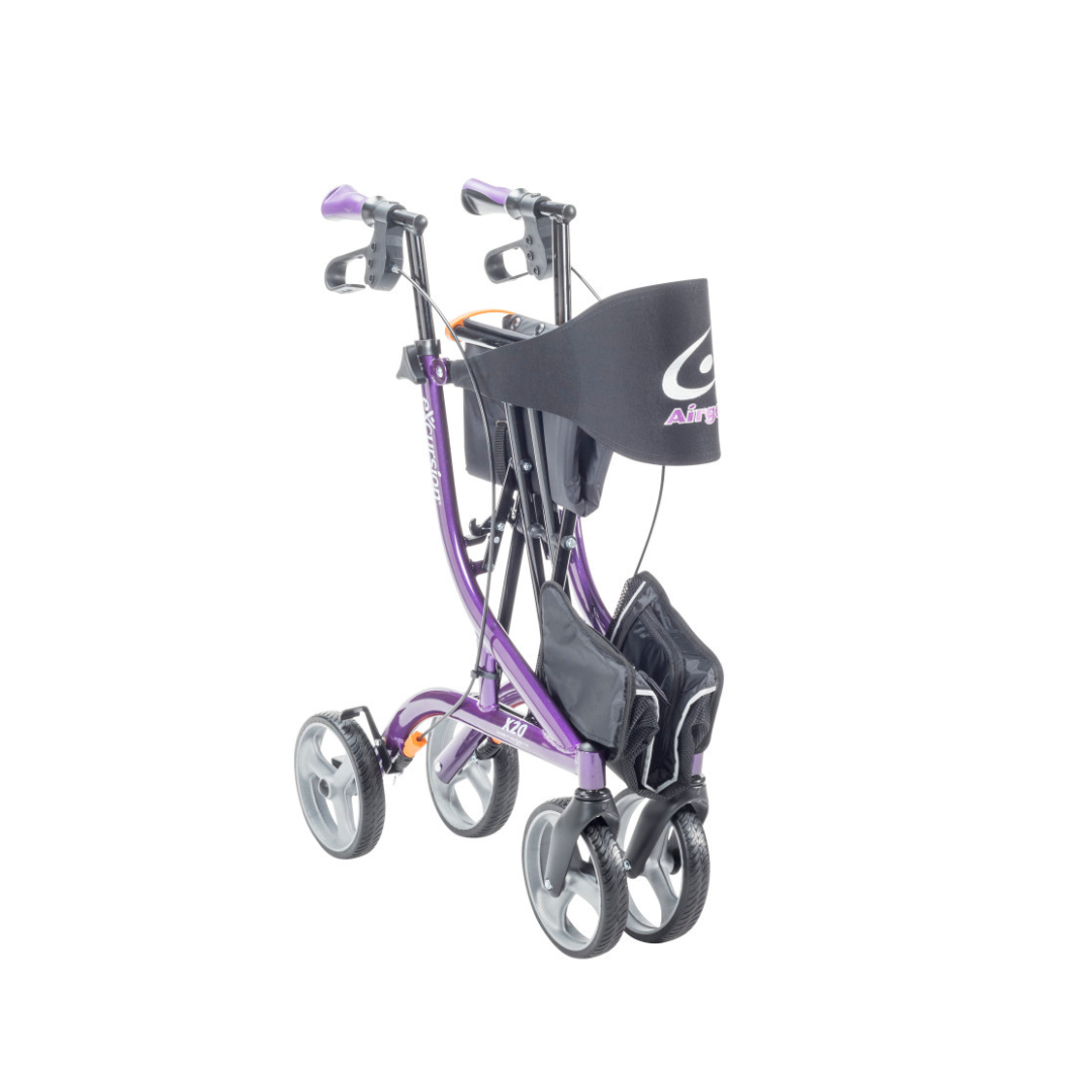 A lightweight, purple Drive Airgo eXcursion X20 side-fold rollator with four wheels, hand brakes, a black storage pouch, and a black fabric basket attached to the front is shown folded.