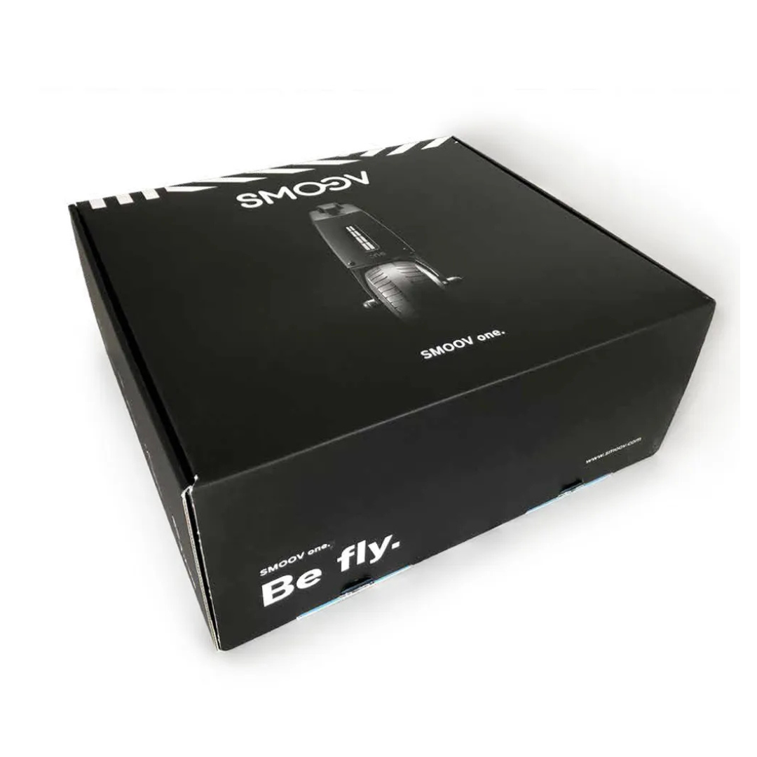 A black rectangular box with "SMOOV" and "Be fly." printed on it, featuring an image of the Alber SMOOV One Power Assist device on the lid, is shown against a white background.