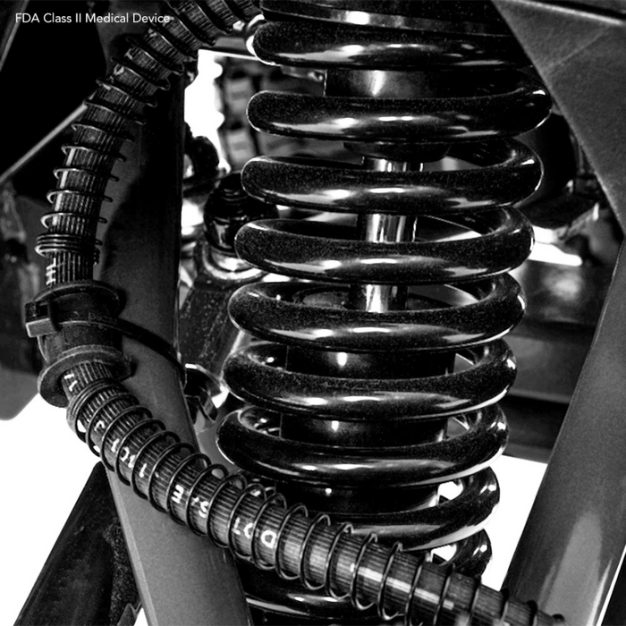 Close-up of a black coil spring and flexible conduit in a CTS Suspension, part of the Pride Baja® Wrangler® 2 Heavy Duty Outdoor Scooter. The image showcases the intertwined metal structure, emphasizing its robust design built for rugged terrain.