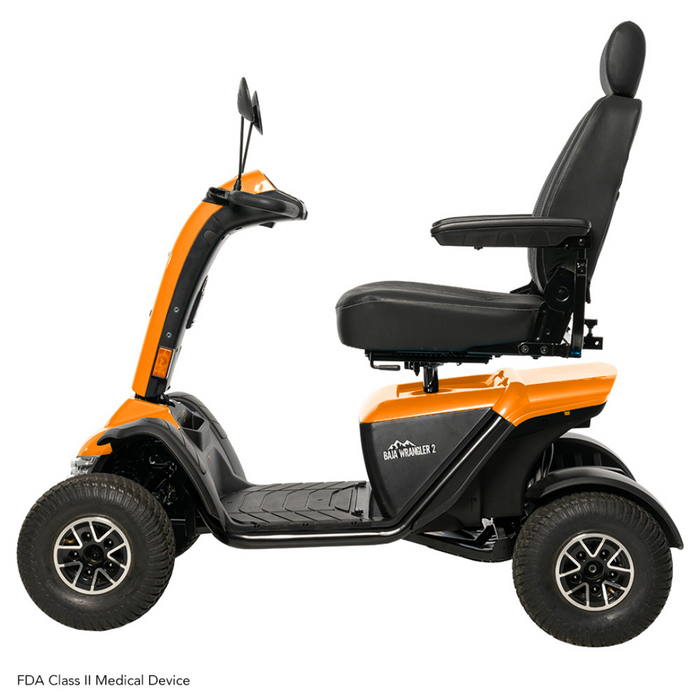 Side view of the Pride Baja® Wrangler® 2 Heavy Duty Outdoor Scooter in orange and black, featuring a padded seat with armrests, backrest, and four large wheels for tough terrain. Image text: FDA Class II Medical Device.