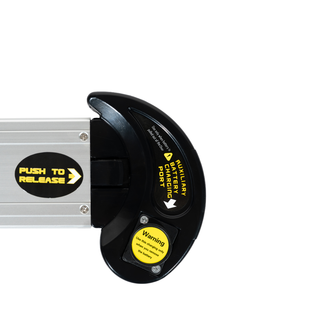 Close-up of the Battery for Forcemech Navigator Powerchair (24V 6.6Ah Lithium NCM 622) with labels: PUSH TO RELEASE, AUXILIARY CHARGING PORT, and a yellow warning sticker, against a white background. FAA approved.
