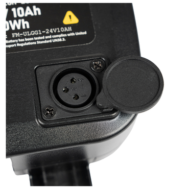 Close-up of a black three-pin electrical socket with a hinged cover, attached to a device labeled with battery and voltage details—compatible with the Forcemech Replacement Battery for G10 Carbon Powerchair.